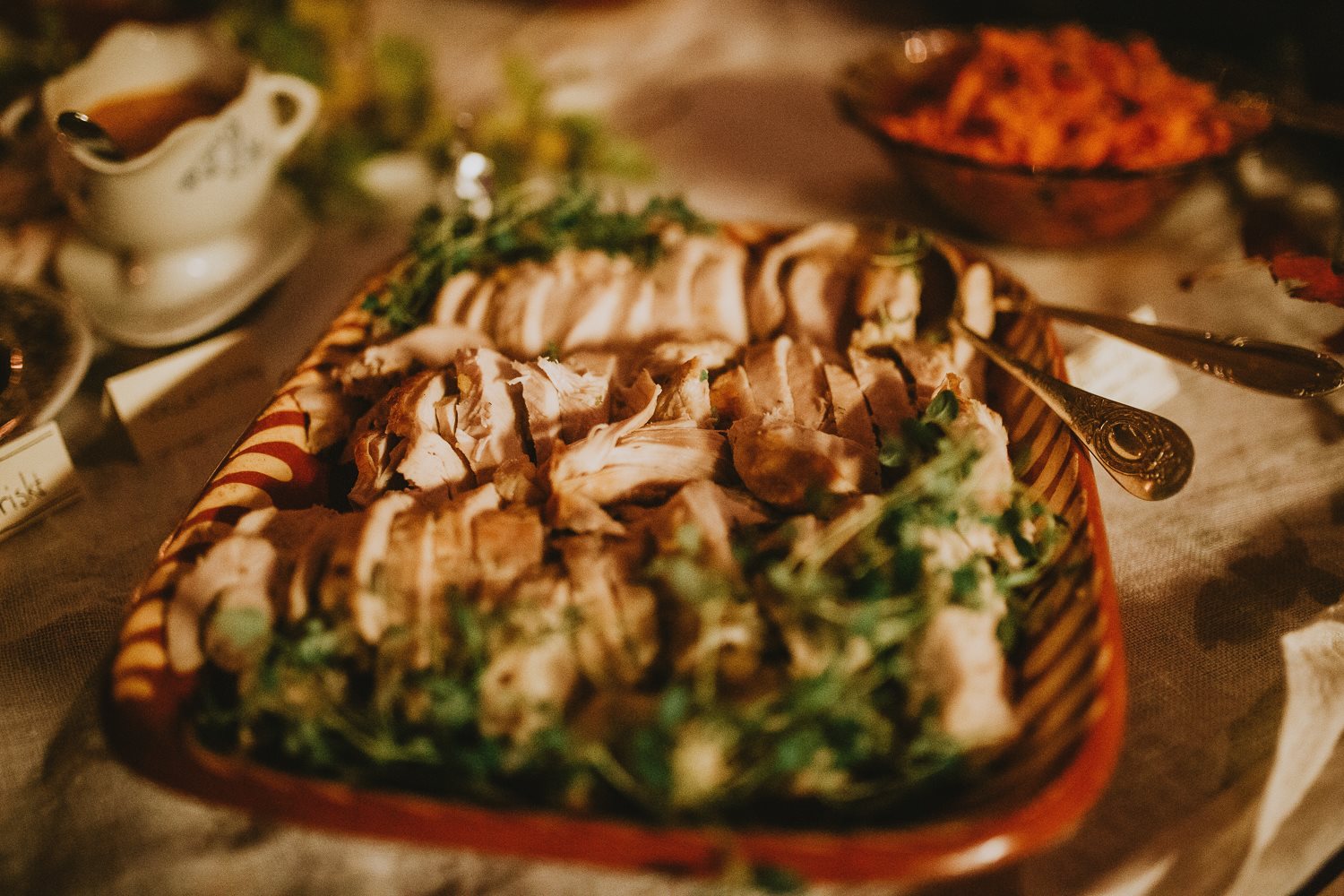 Skivat kött med örter på ett rustikt fat på middagsbuffén.