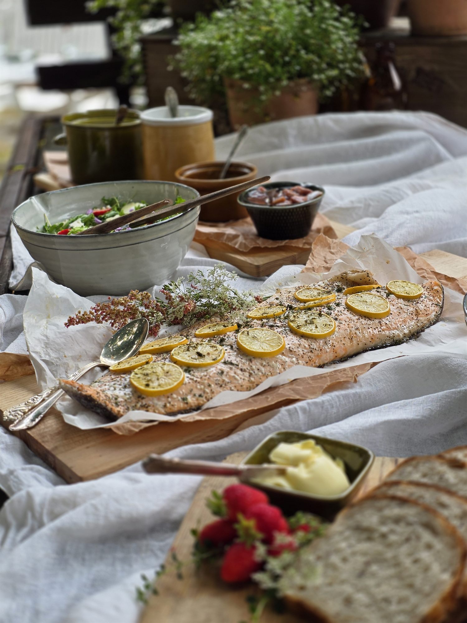 Uppdukad buffé på ett linnedukat bord i Rönnås Lada, med nybakat bröd och tillbehör.